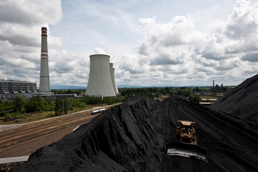 Na skládke uhlia prepravujú uhlie buldozéry.